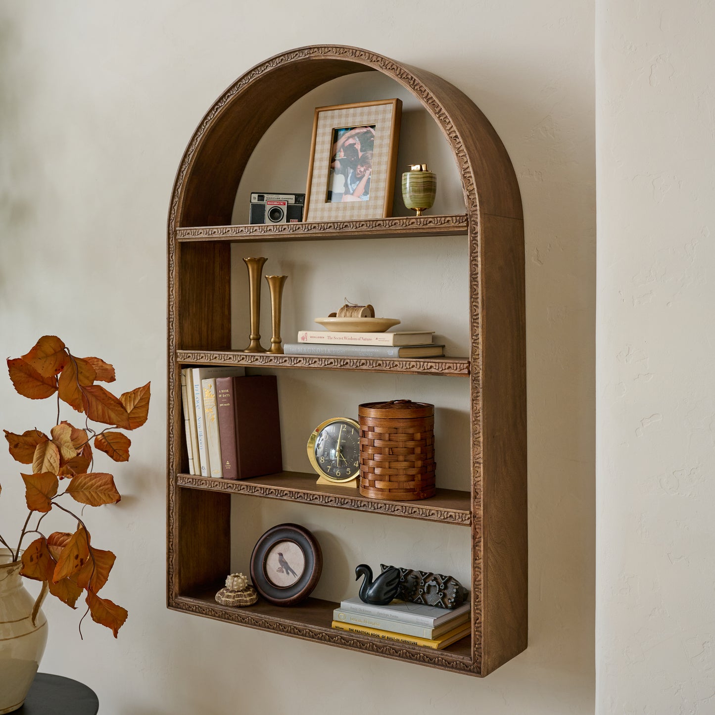 Hand Carved Wooden Archer Shelf shown styled on wall