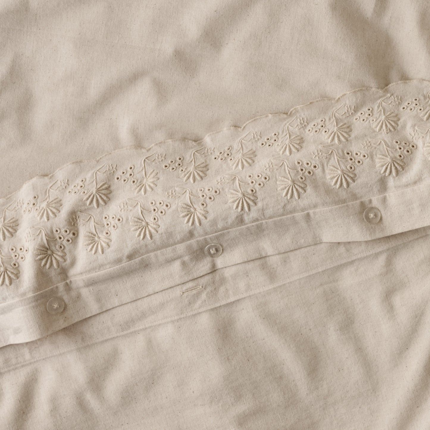 Clara Eyelet Flange Duvet Cover in color Natural button closures up close