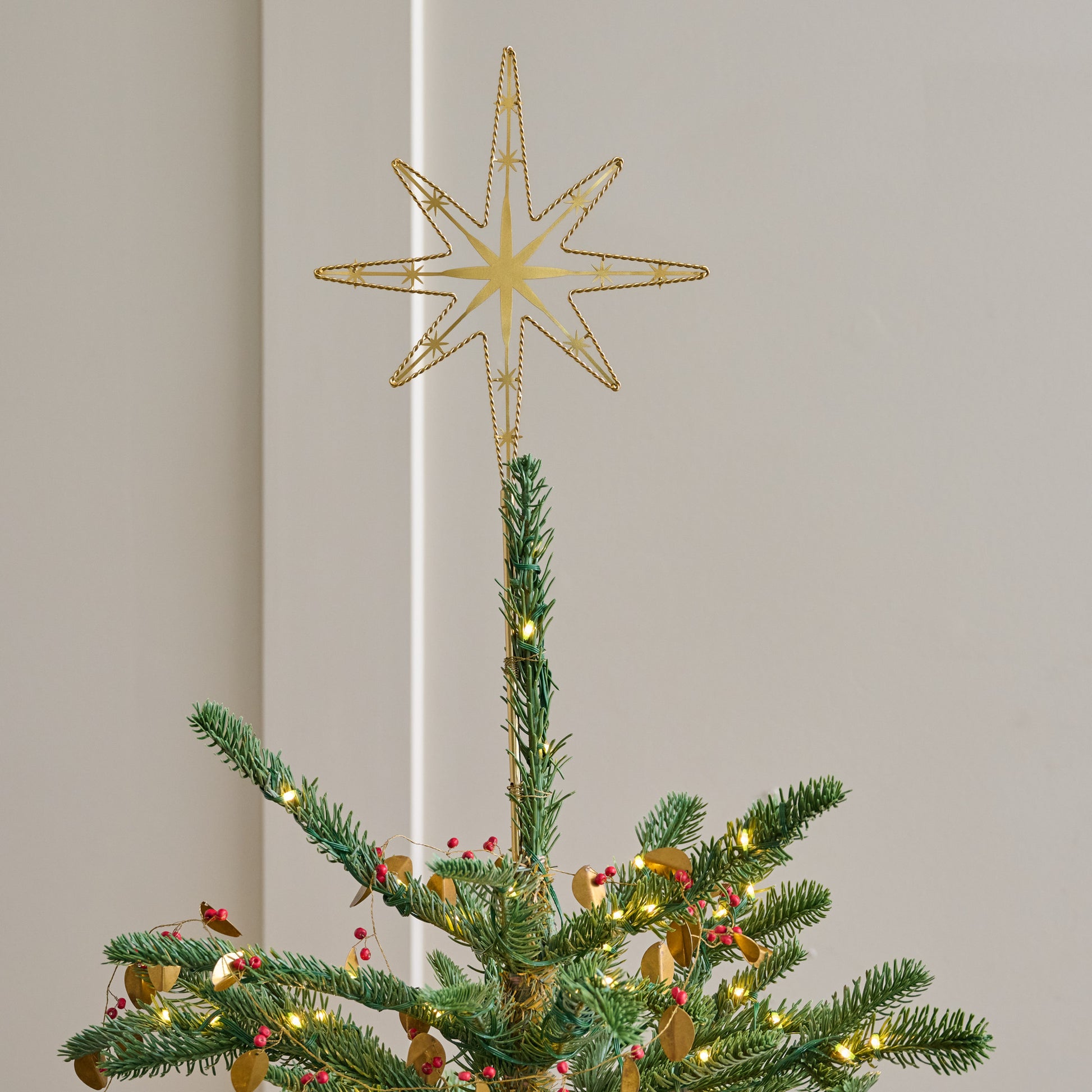 Twisted Brass Star Tree Topper shown on top of tree
