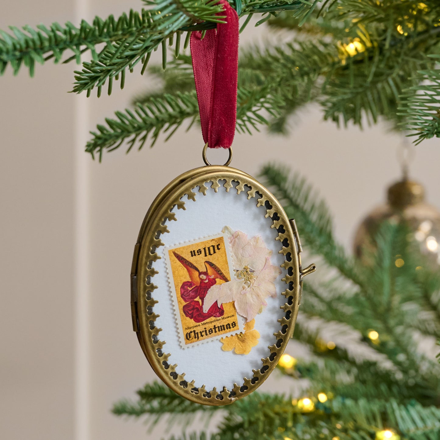 Eloise Photo Frame Ornament shown hung on tree with stamp and flower framed