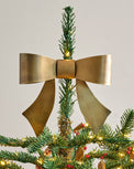 Clara Brass Bow Tree Topper shown on top of tree