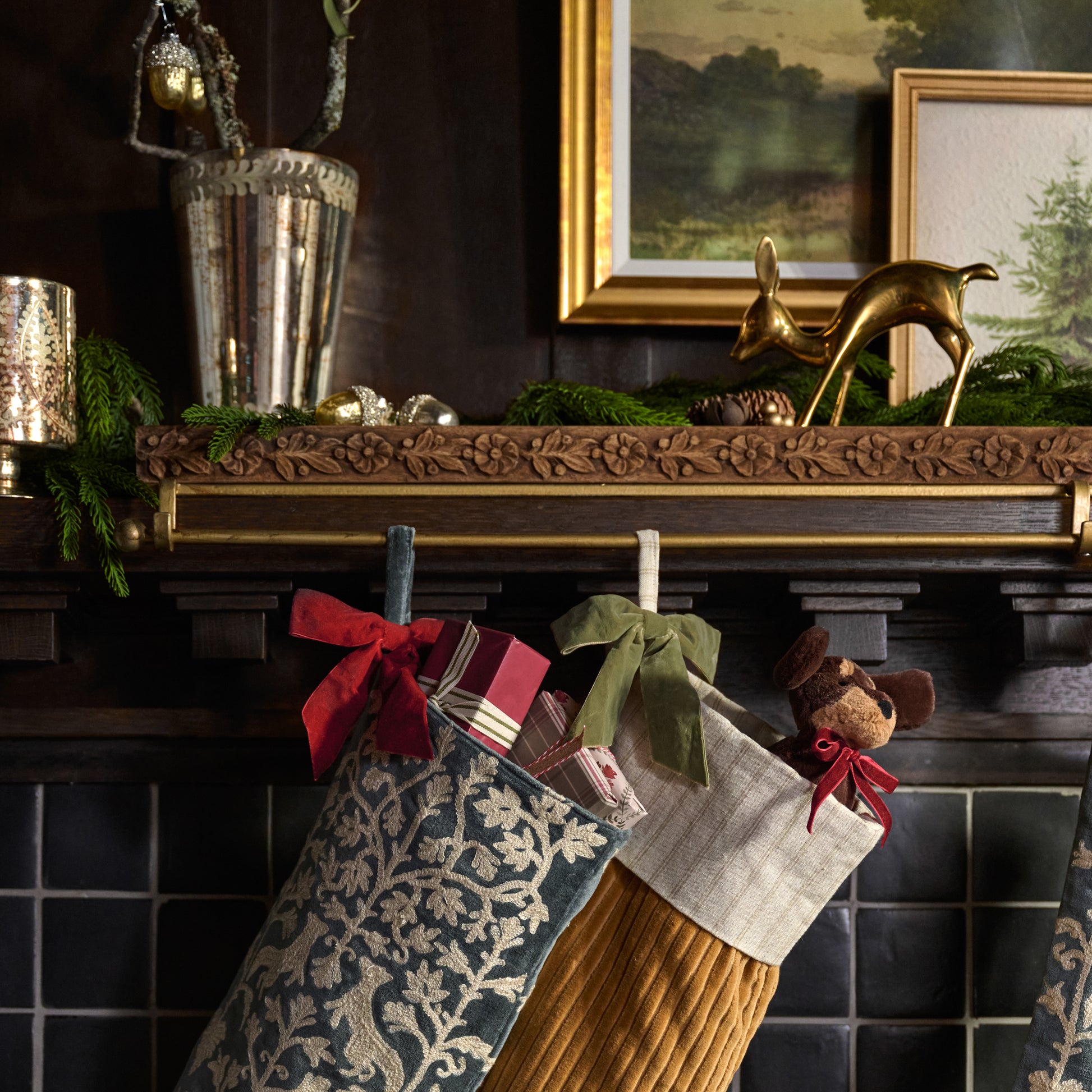 Eleanor Carved Wood Stocking Holder shown holding stockings on mantel