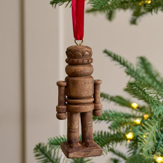 Wooden Nutcracker Ornament shown hung on christmas tree