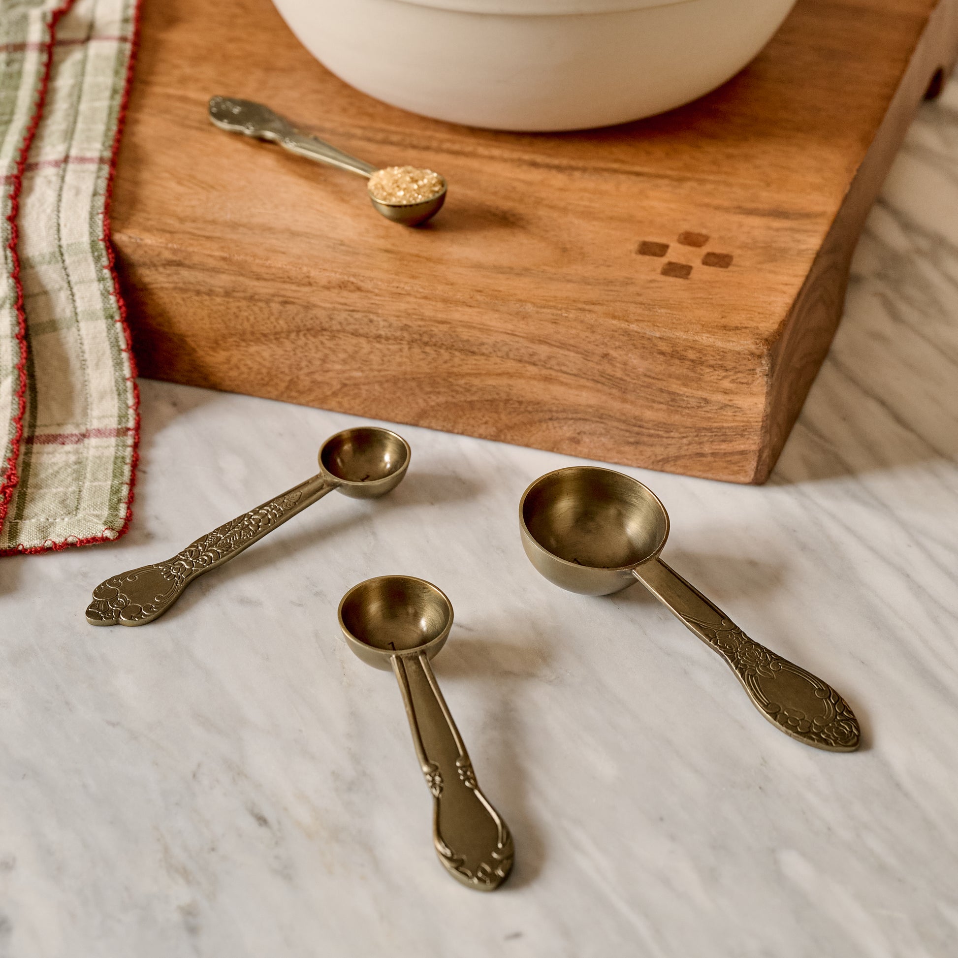 Antique Brass Measuring Spoons shown on kitchen counter