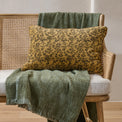Velvet Amber Vines Lumbar Pillow shown on bench with blanket