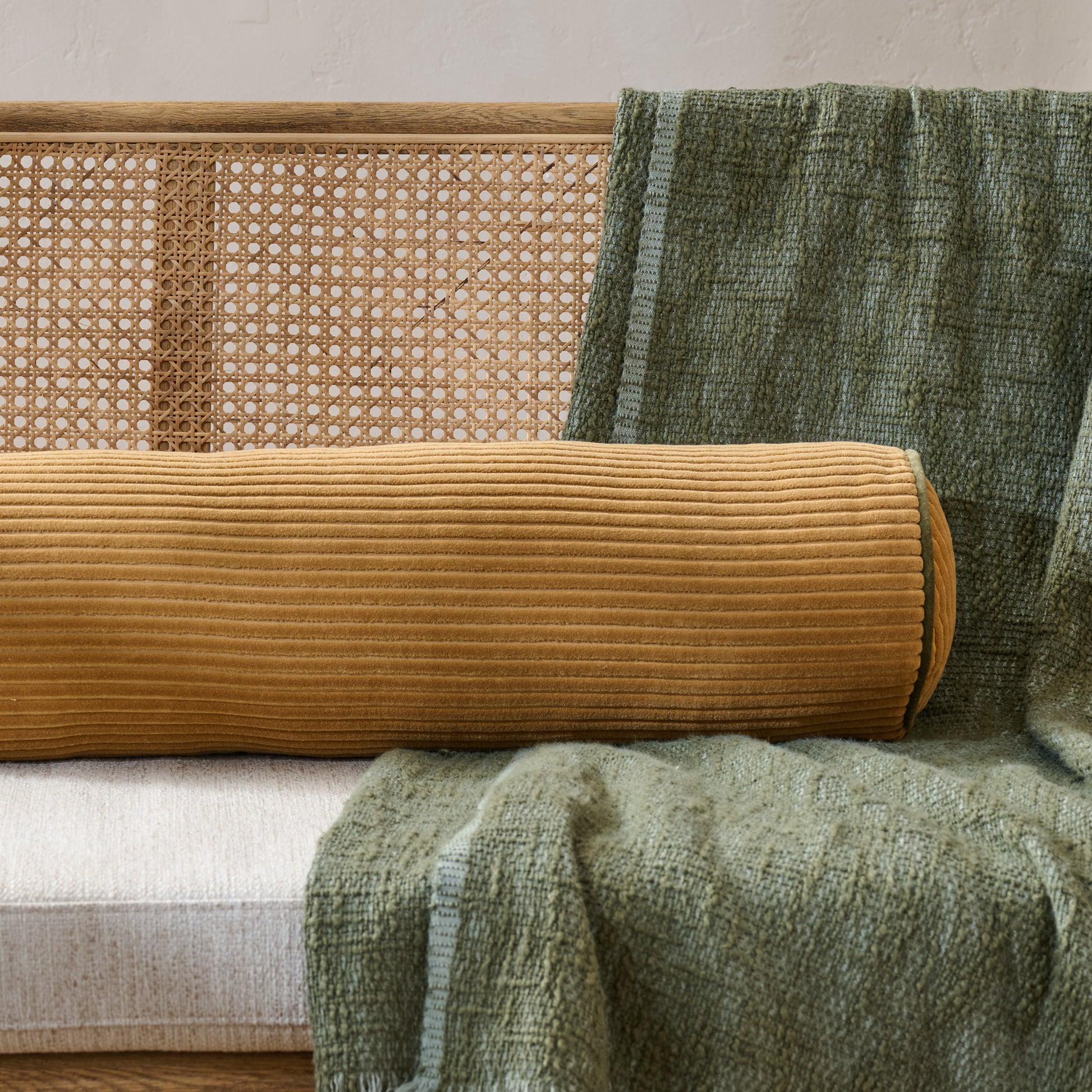Channeled Velvet Bolster Pillow - Golden Brown shown on bench