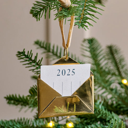 2025 Magnolia Brass Keepsake Envelope Ornament on a tree