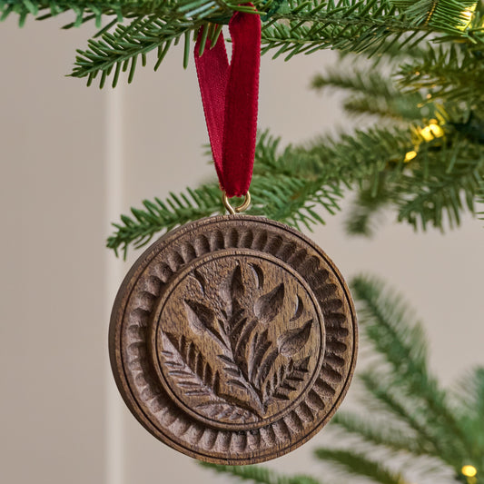 Vintage-Inspired Carved Floral Ornament shown hung from christmas tree branch