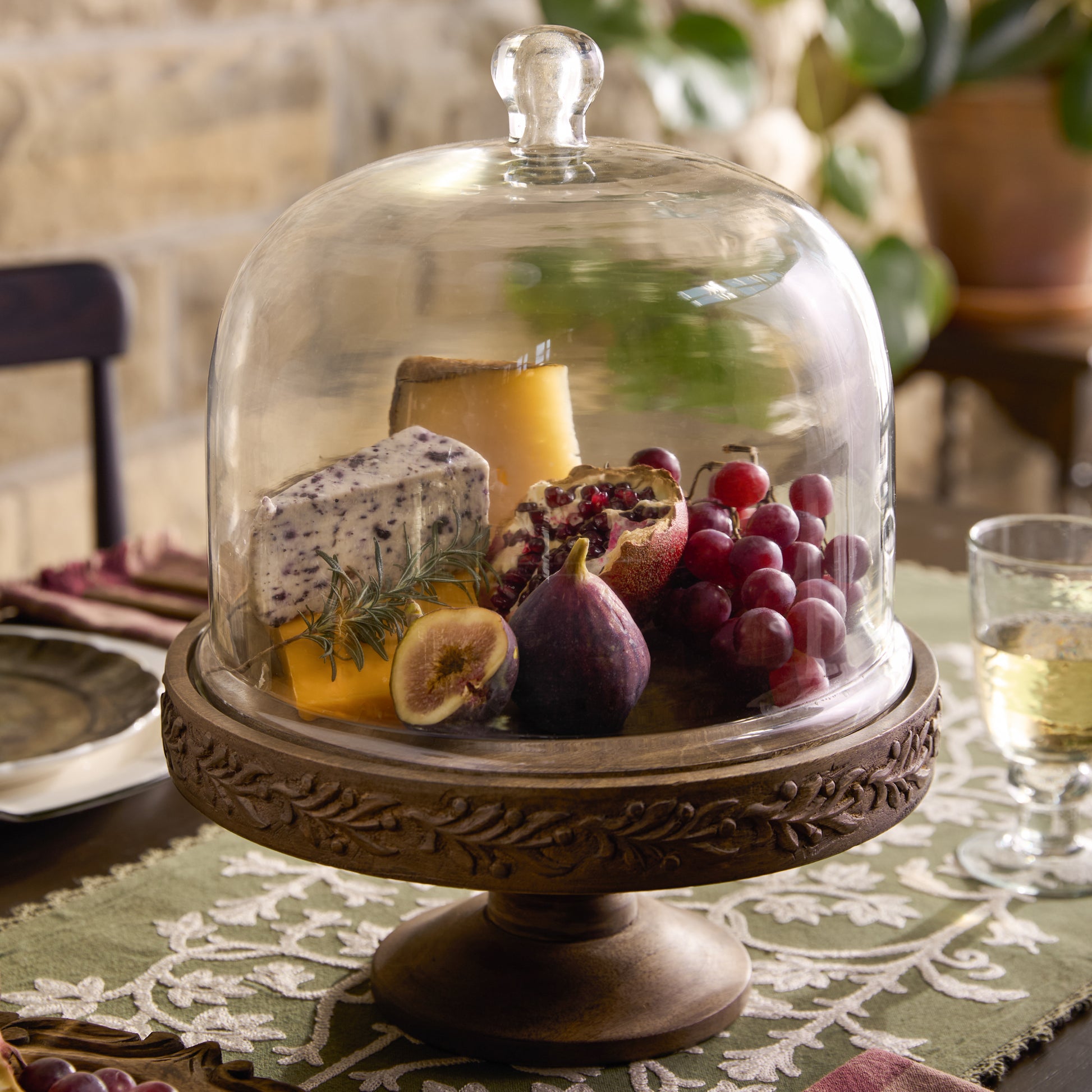 Eleanor Carved Wood Cake Stand with Glass Dome on a table