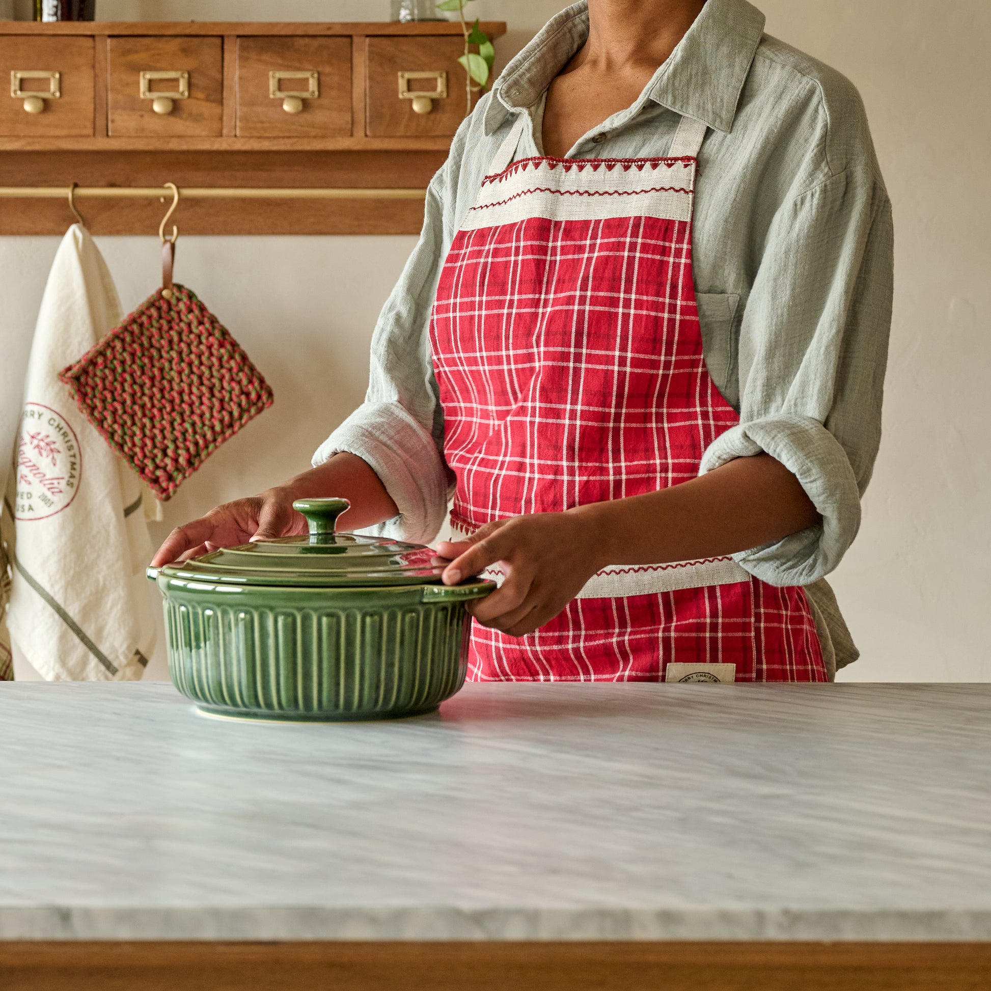 Magnolia Vintage Red Plaid Embroidered Apron shown on person in kitchen