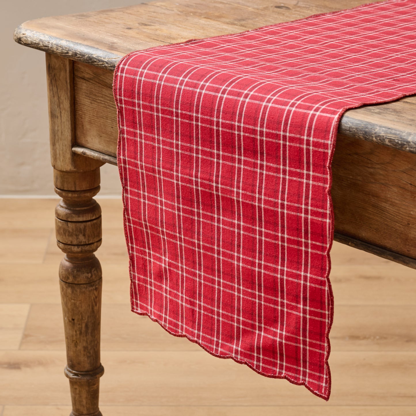 Magnolia Festive Plaid Reversible Table Runner shown on table with red plaid side facing up