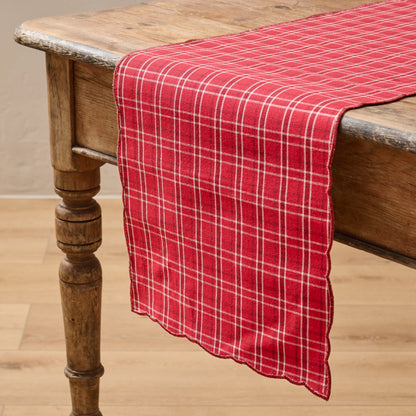 Magnolia Festive Plaid Reversible Table Runner shown on table with red plaid side facing up