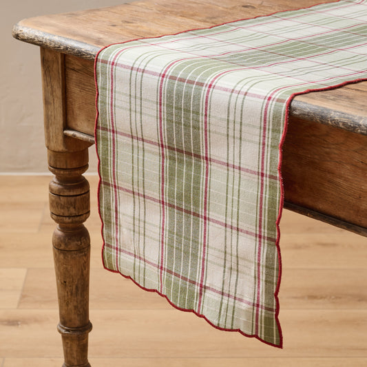 Magnolia Festive Plaid Reversible Table Runner shown on table with green plaid side facing up