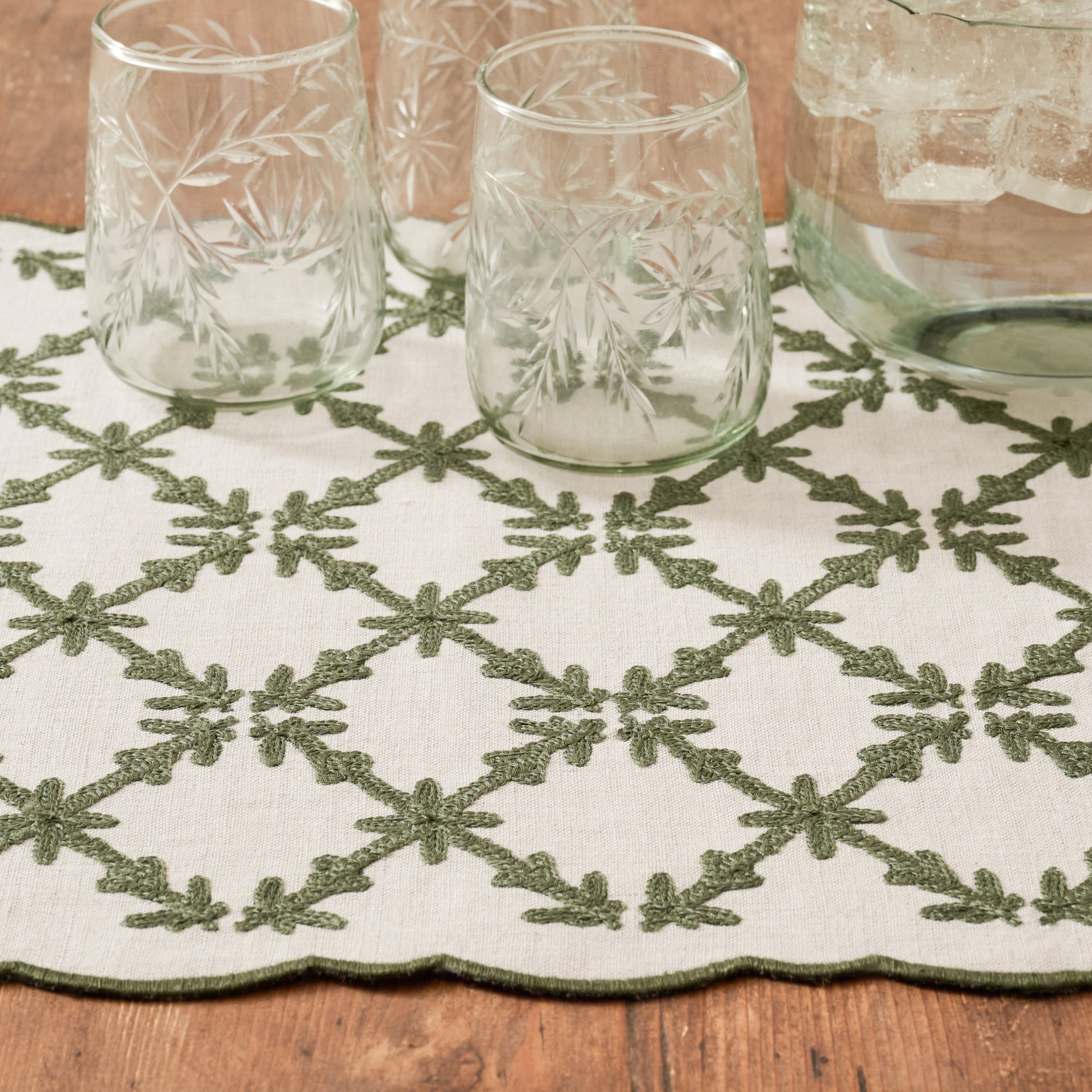 Moss Green Eleanor Embroidered Table Runner up close shown with etched glasses
