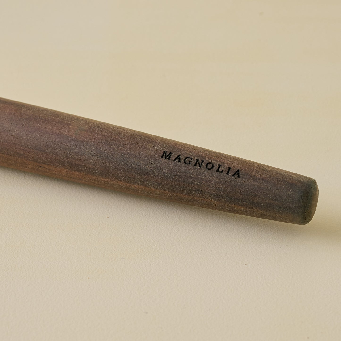 The Gristmill Collection Walnut Rolling Pin zoomed in with 'Magnolia' etched in