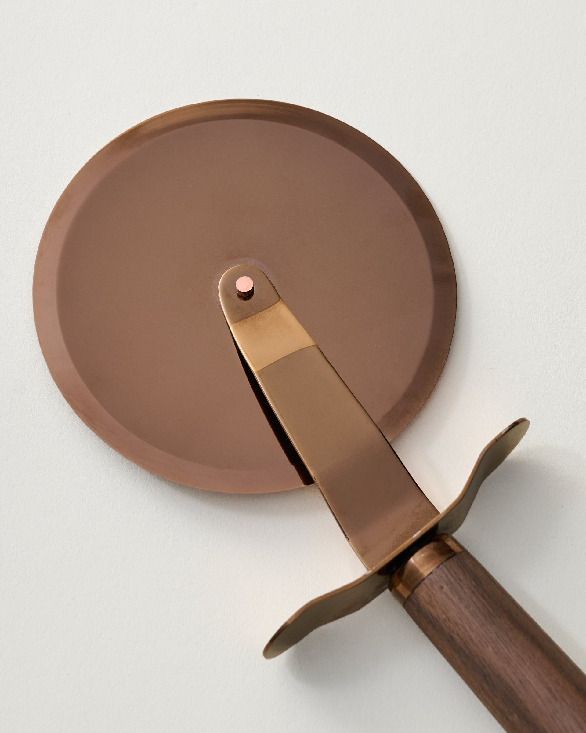 The Gristmill Collection Walnut Handle Pizza Cutter close up of blade