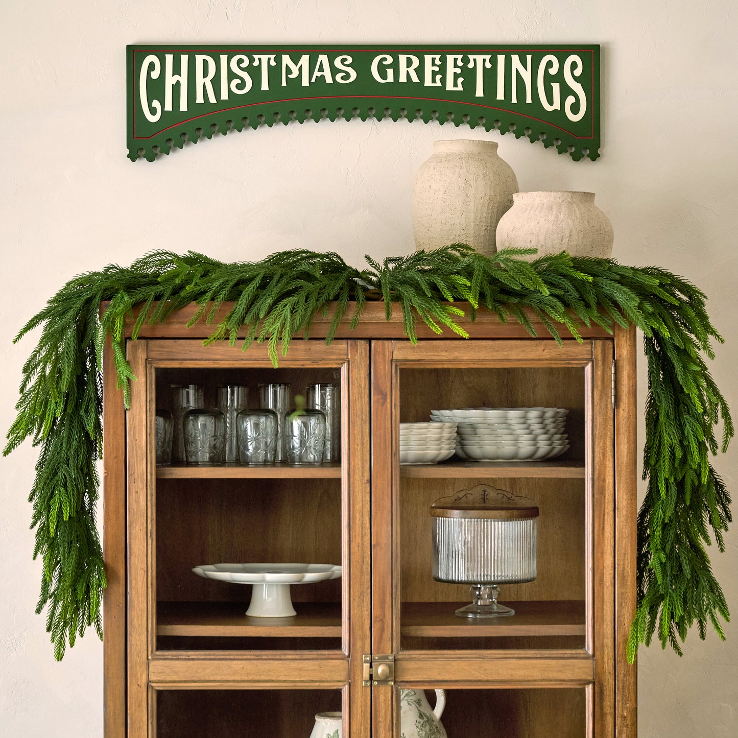 Christmas Greetings Wooden Sign shown hung above china hutch