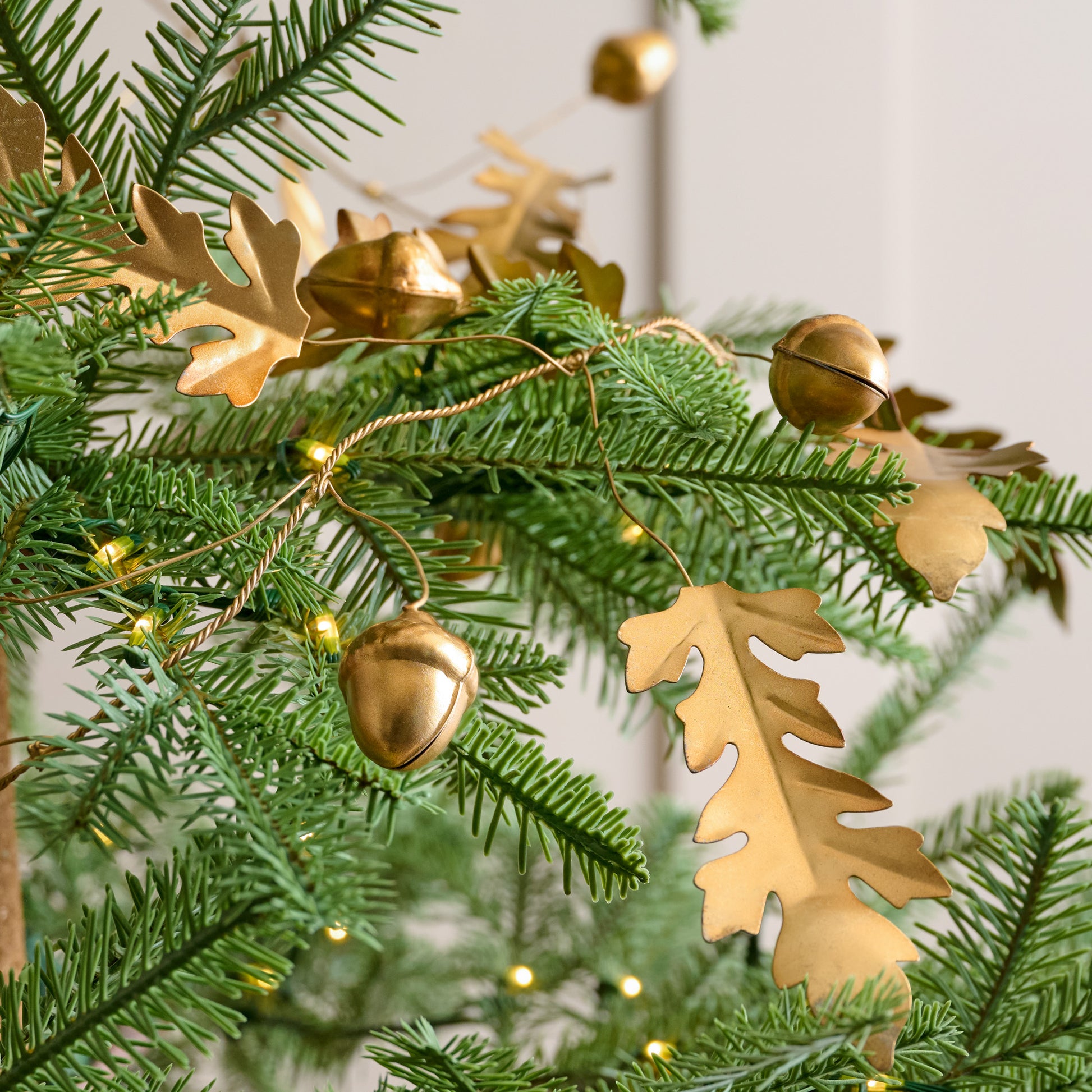 Foraged Leaf and Acorn Brass Garland shown on tree