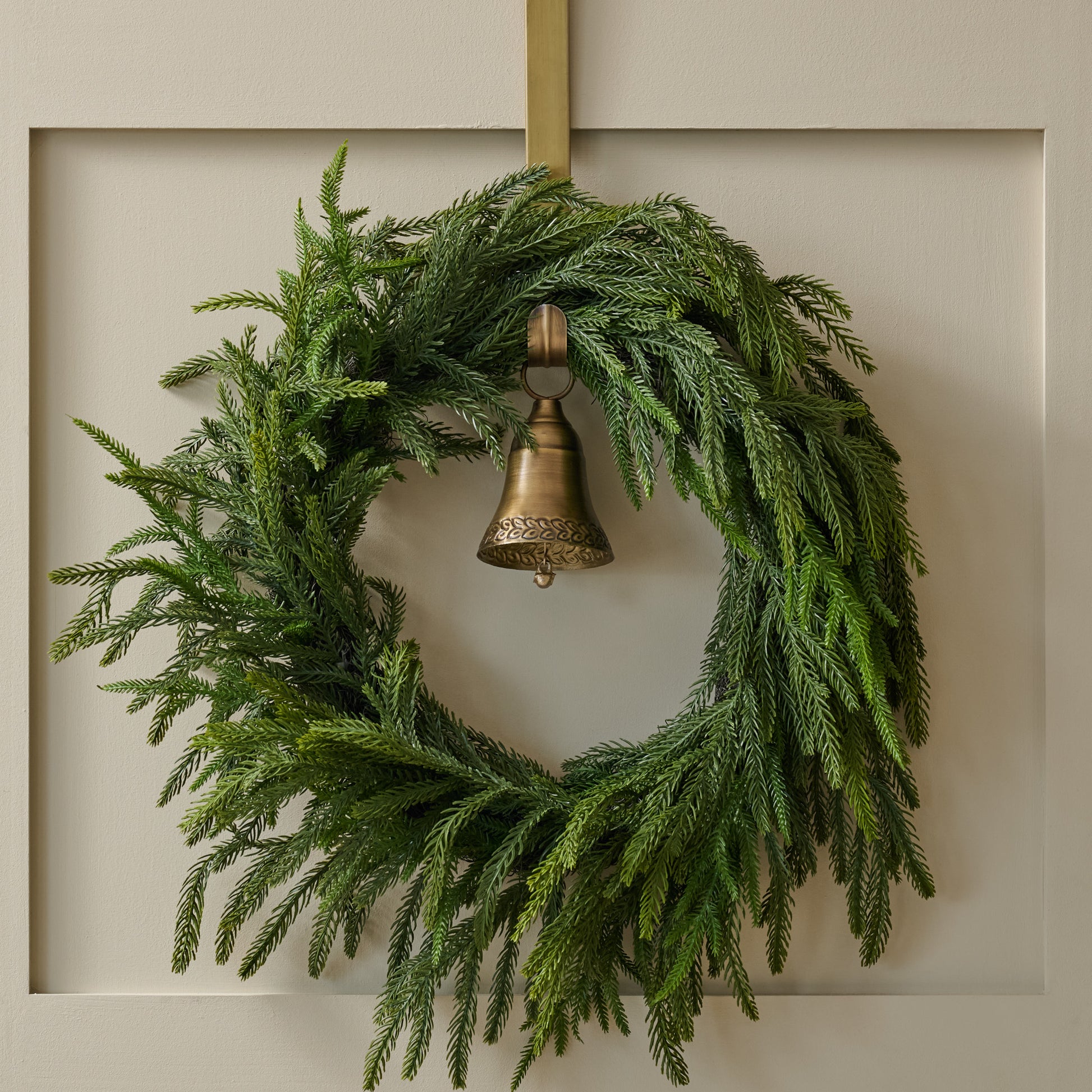 Gabriel Brass Bell Wreath Hanger shown holding wreath