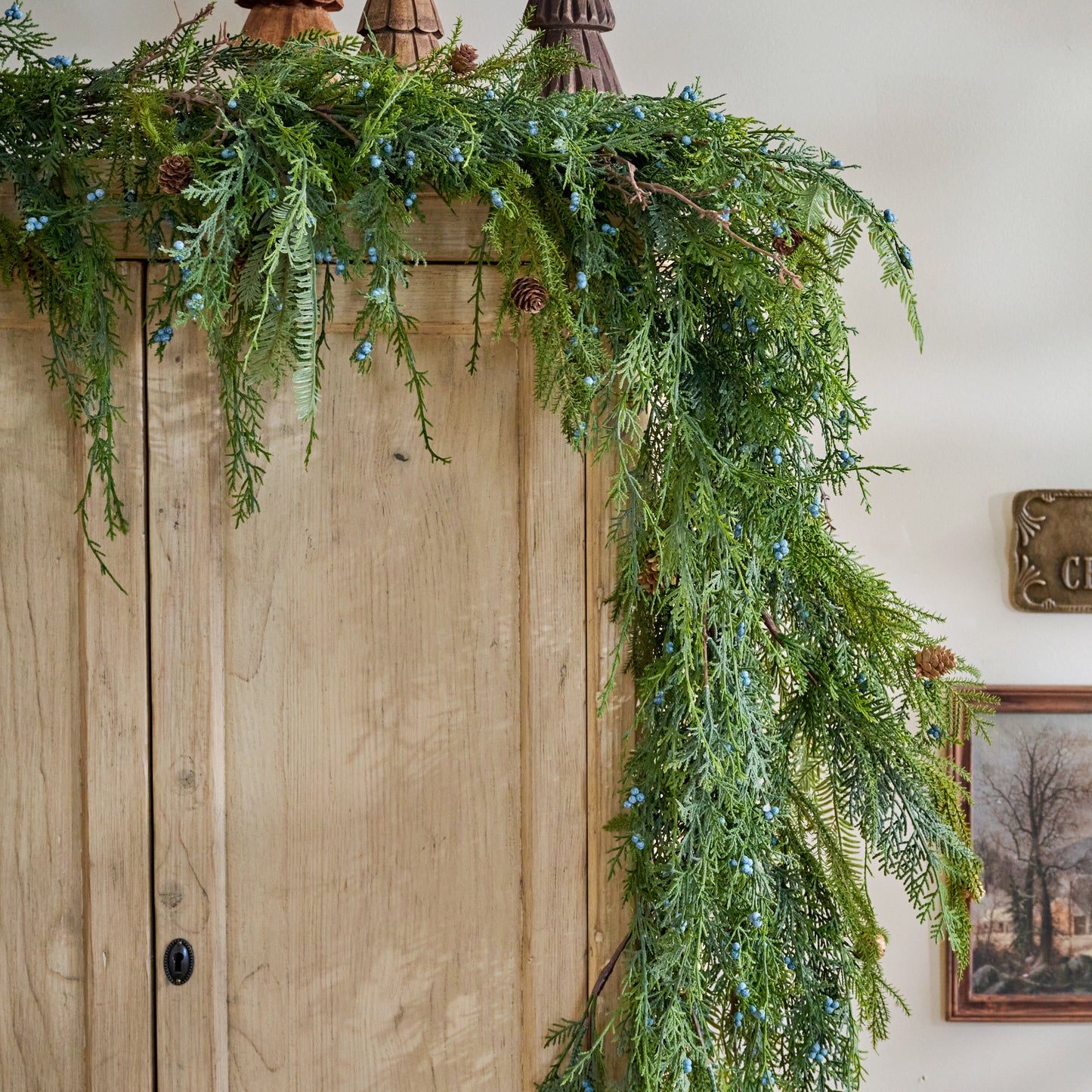 Real Touch Juniper Berry Pine Garland - 72" shown hung on cabinet