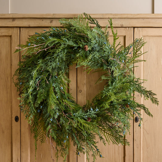 Real Touch Juniper Berry Pine Wreath shown hung on cabinet