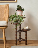Winnie Tiered Plant Stand in a room with potted plants placed on top