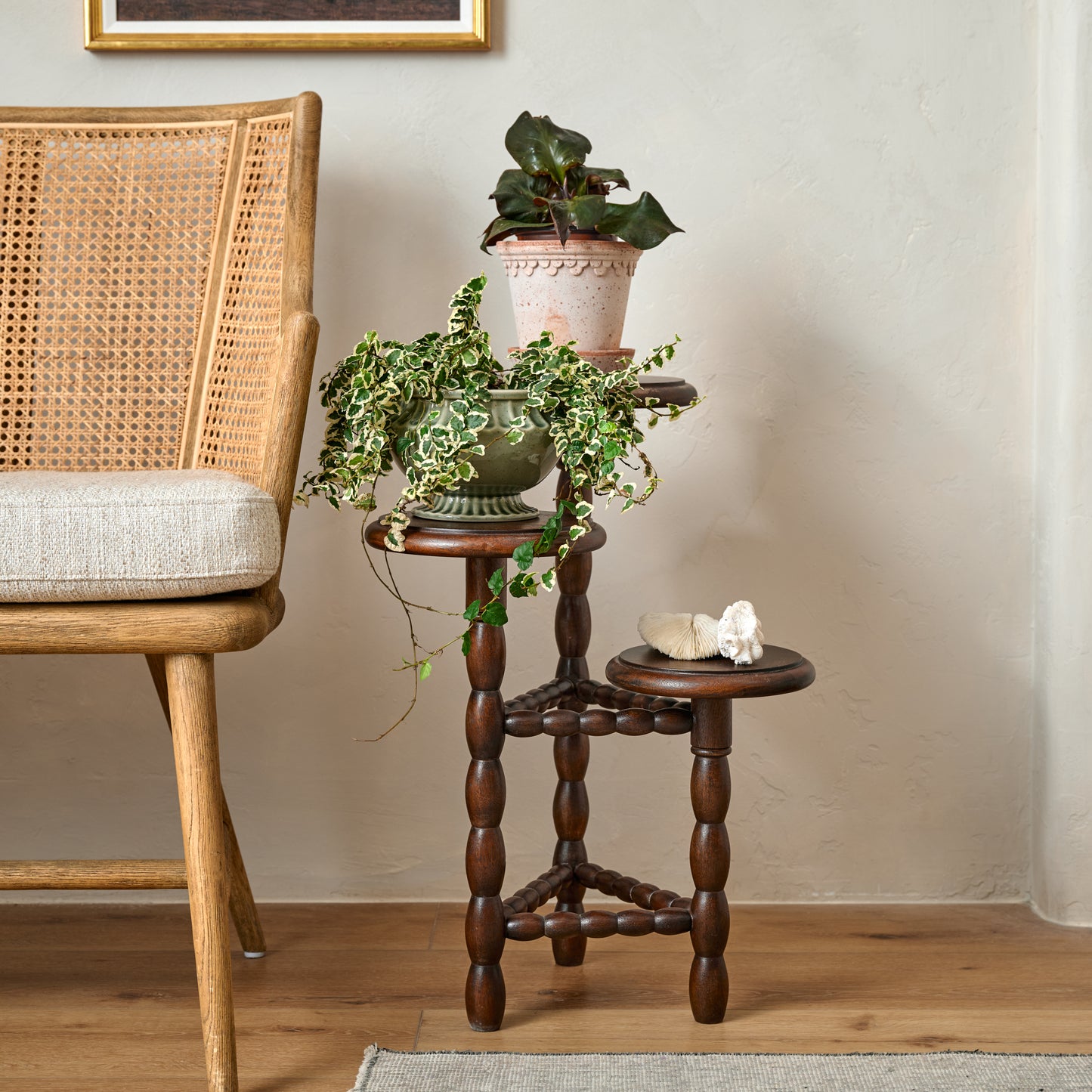 Winnie Tiered Plant Stand in a room with potted plants placed on top
