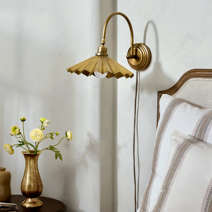 Brass Pleat Plug-in Sconce in bedroom next bed and nightstand