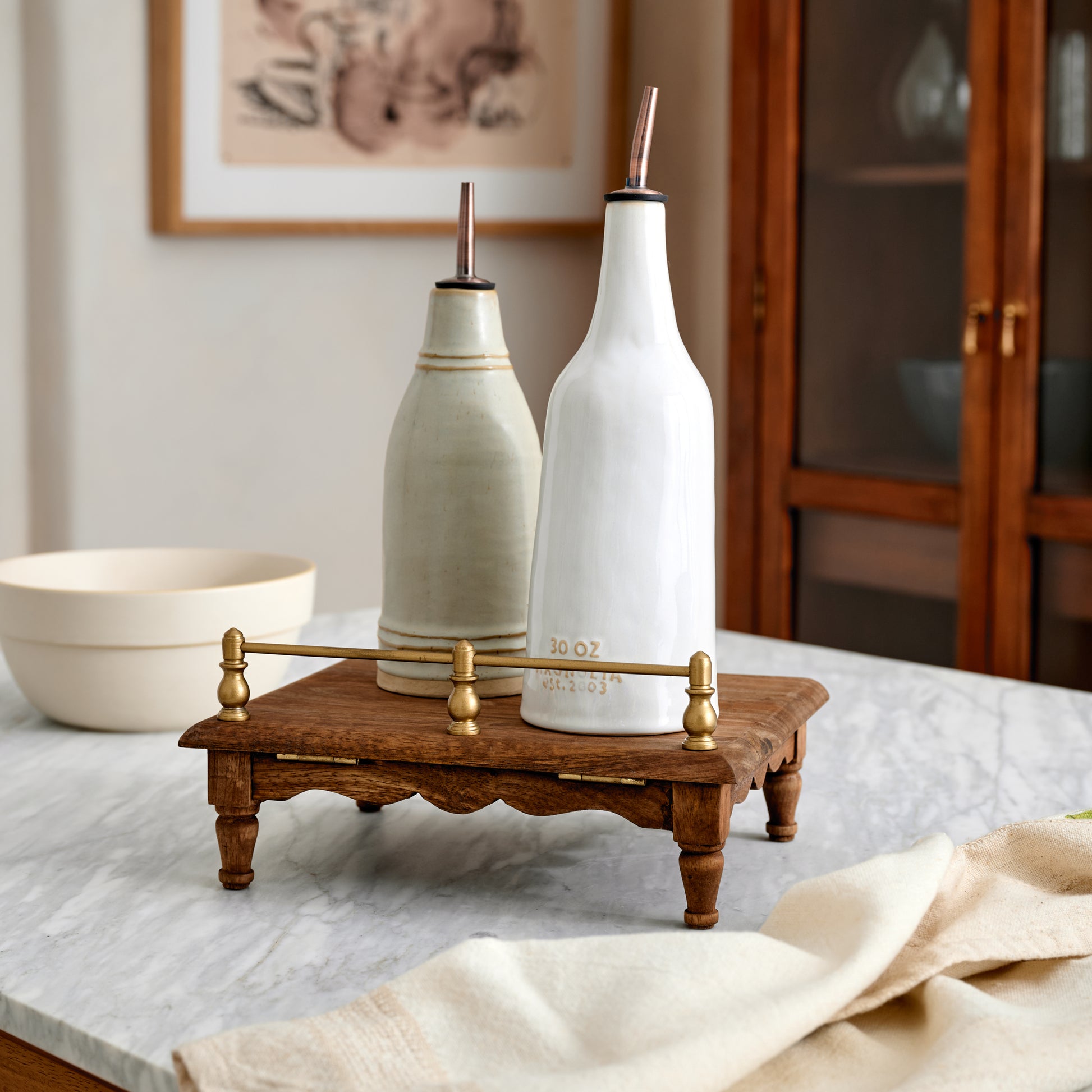 Vintage-Inspired Cookbook Holder + Riser shown as a riser with decorative kitchen tools holding oil or vinegar inside