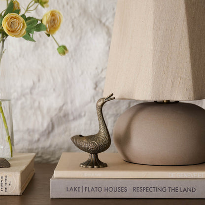 Vintage Inspired Brass Duck Taper Holder styled on top coffee table books and table lamp