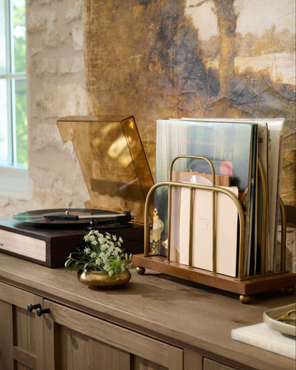 Short Antique Brass and Wood Media Stand holding vinyl records in a room