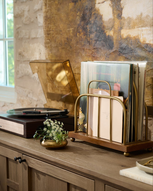 Short Antique Brass and Wood Media Stand holding vinyl records in a room