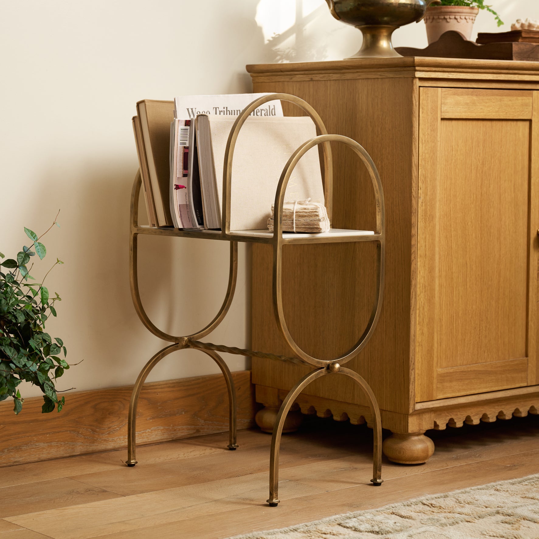 Juliet Marble and Brass Media Stand styled with books and magazines in a room