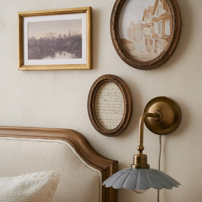 Caroline Carved Wood Oval Photo Frame in a bedroom above bedframe next to scalloped wall sconce