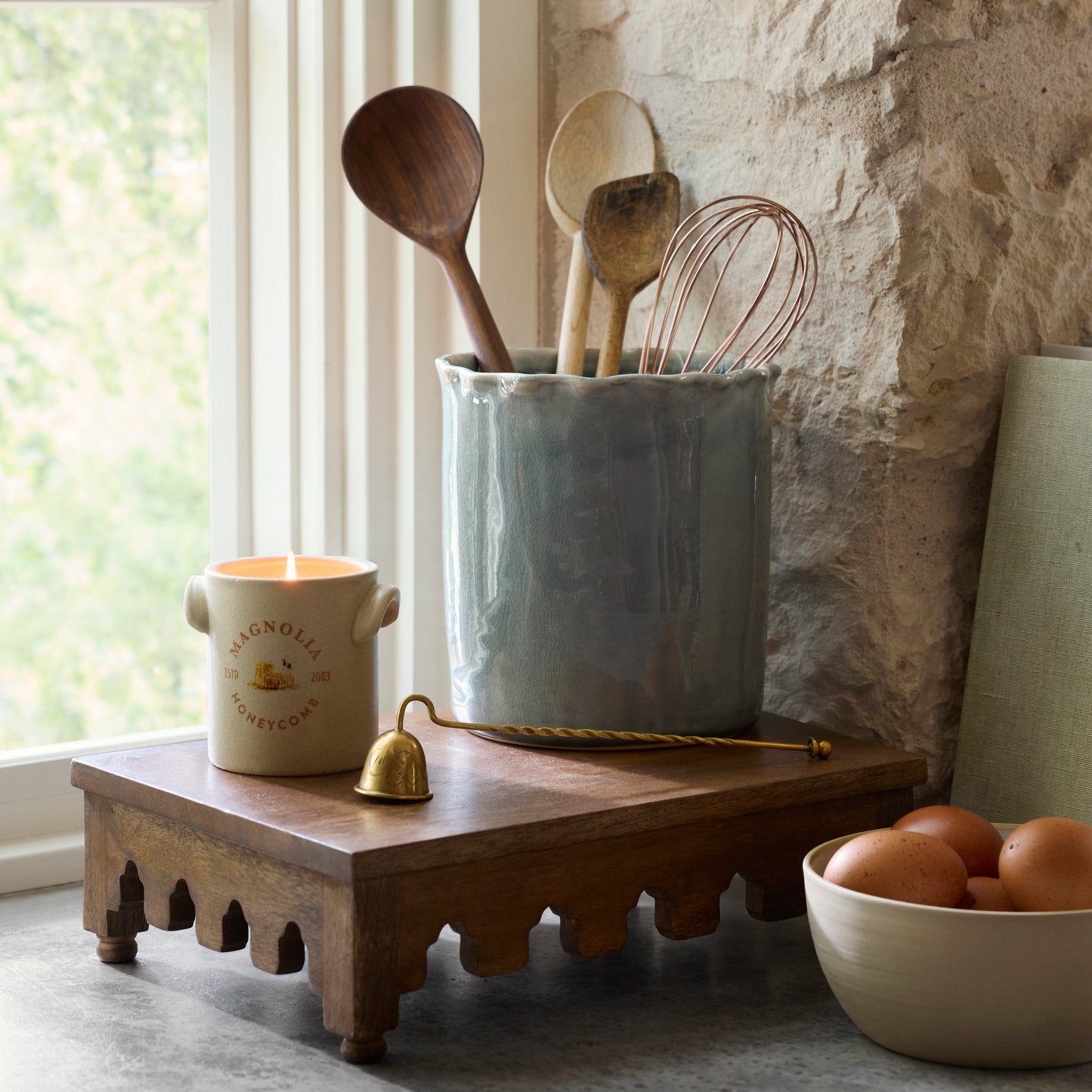 Archie Scalloped Wooden Riser in a kitchen with candle lit and canister with kitchen tools