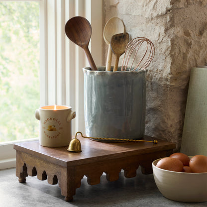 Archie Scalloped Wooden Riser in a kitchen with candle lit and canister with kitchen tools