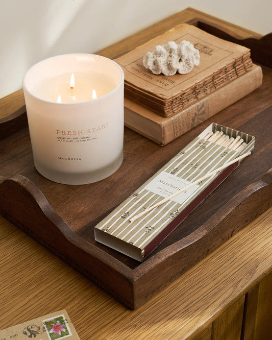  'Fresh Start' Candle on a wooden tray with green matchsticks.