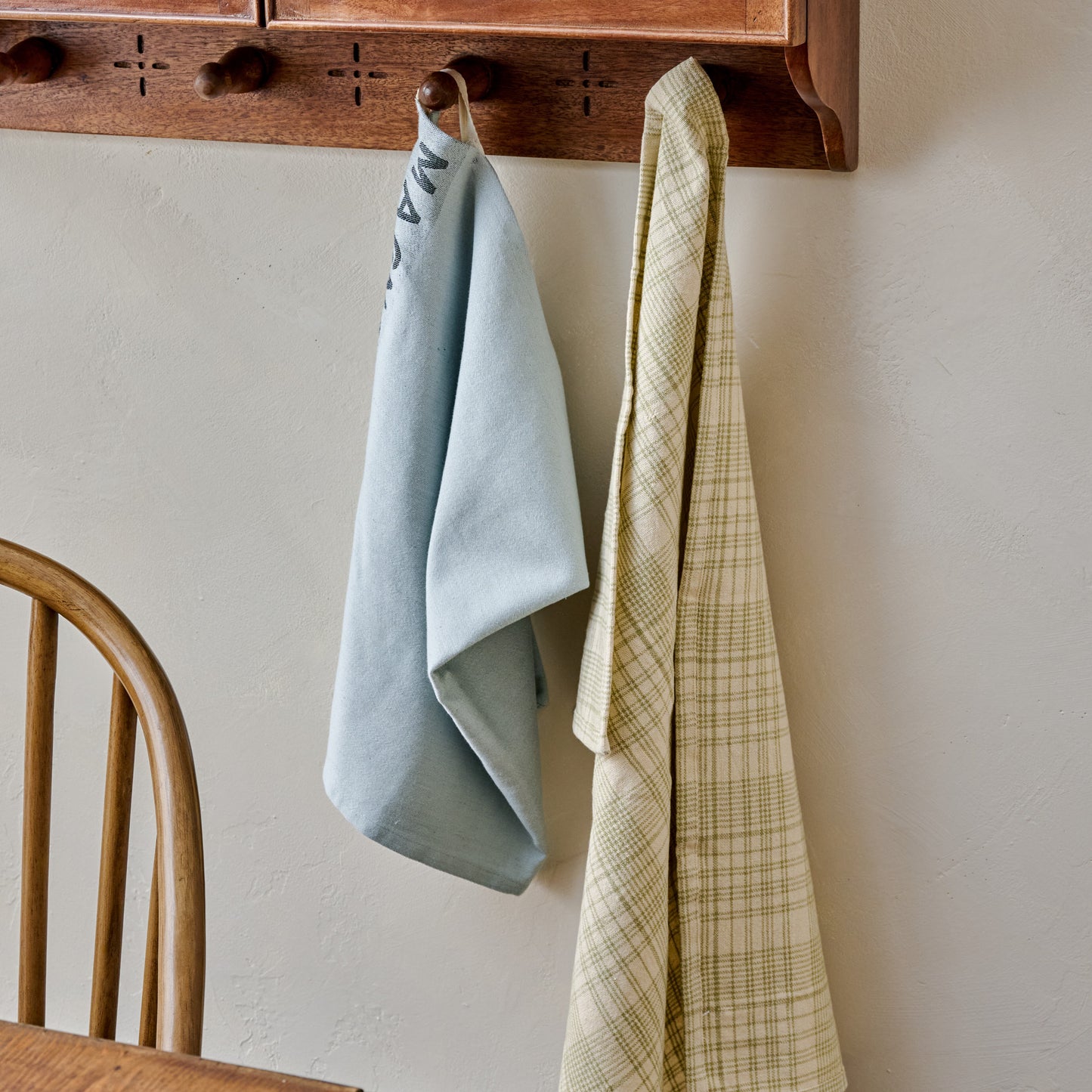 Magnolia Fern Green Windowpane Tea Towel hung up on wall hook