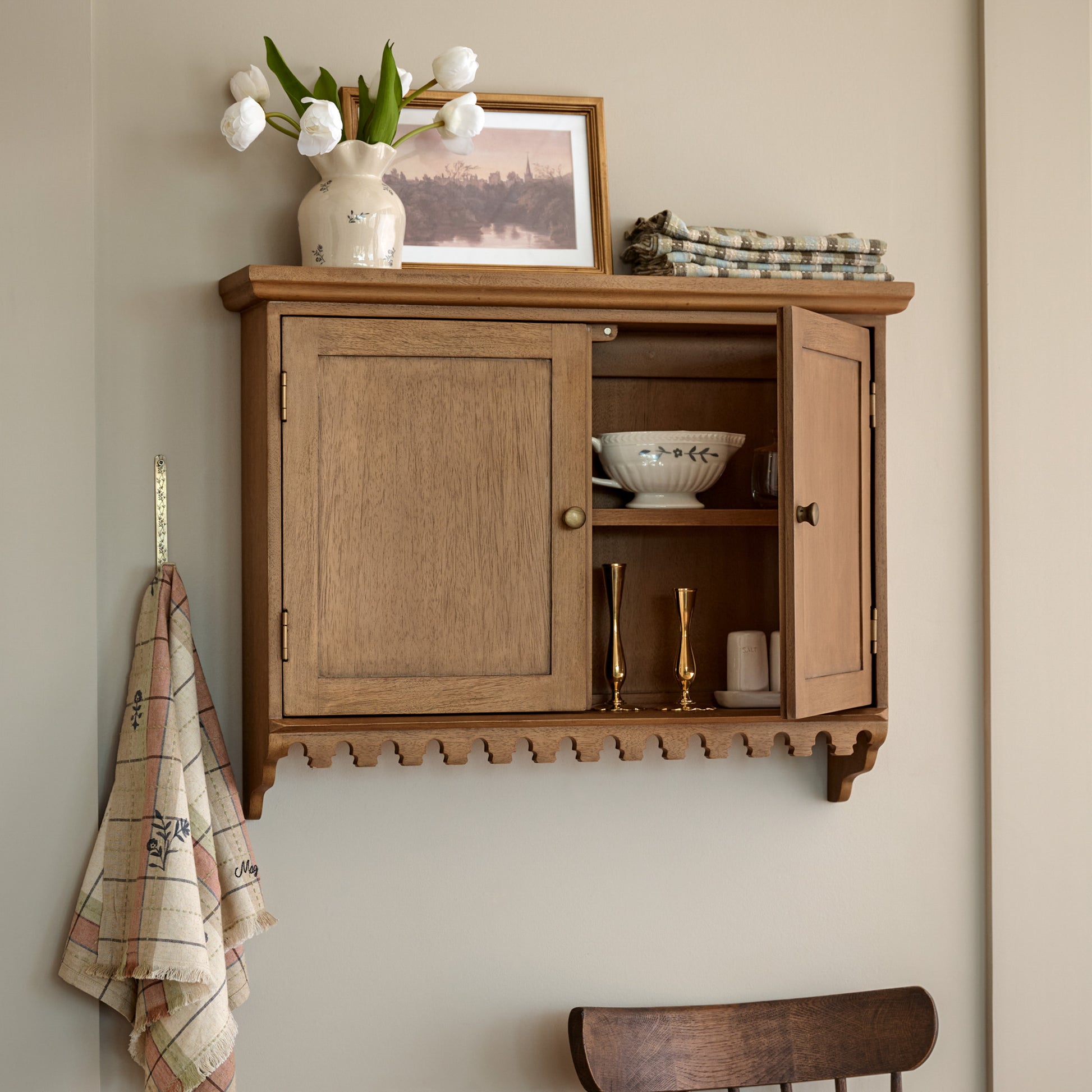Archie Scalloped Wooden Wall Cabinet styled with serveware, wall decor and table linens