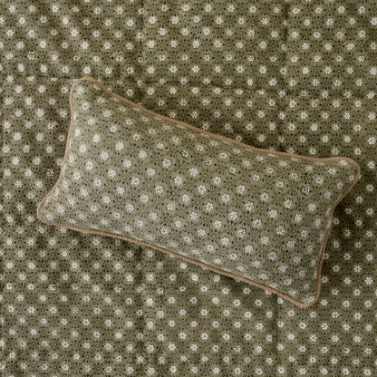 Thea Reversible Lumbar Pillow (small) on top of quilt bedding