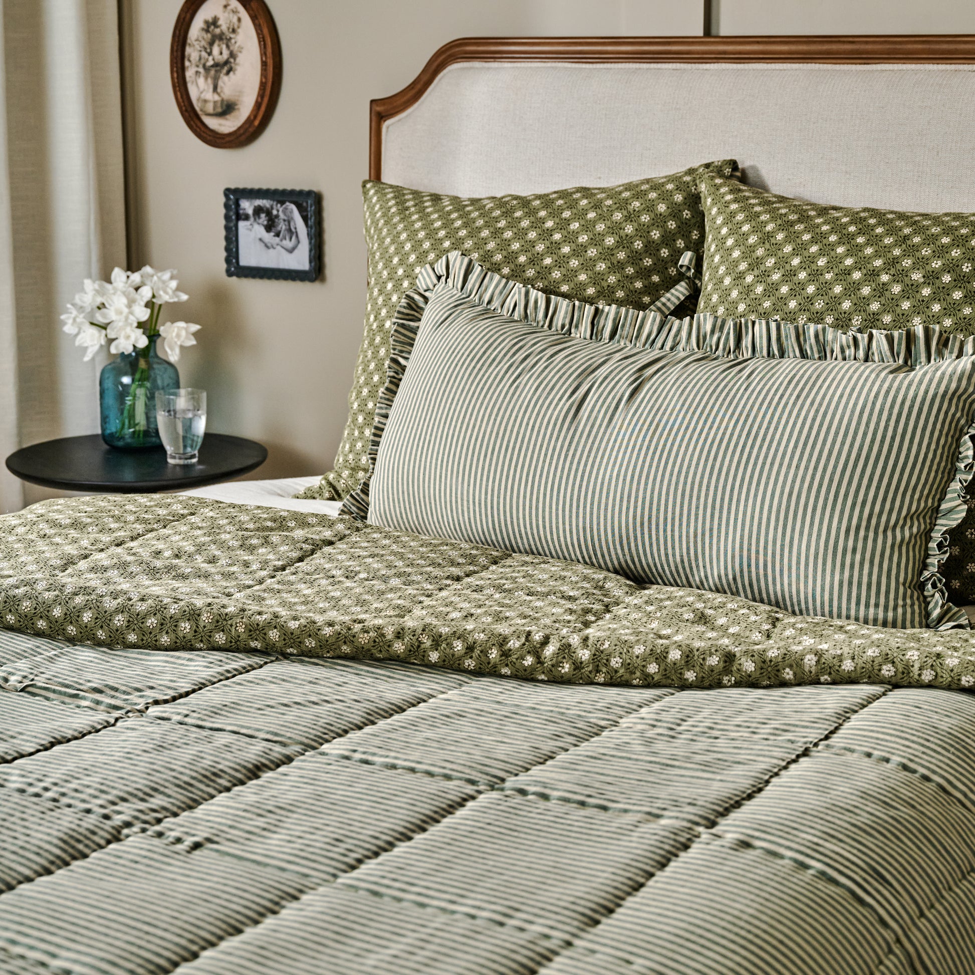 Thea Reversible Quilt with stripe reversible showcased on bed