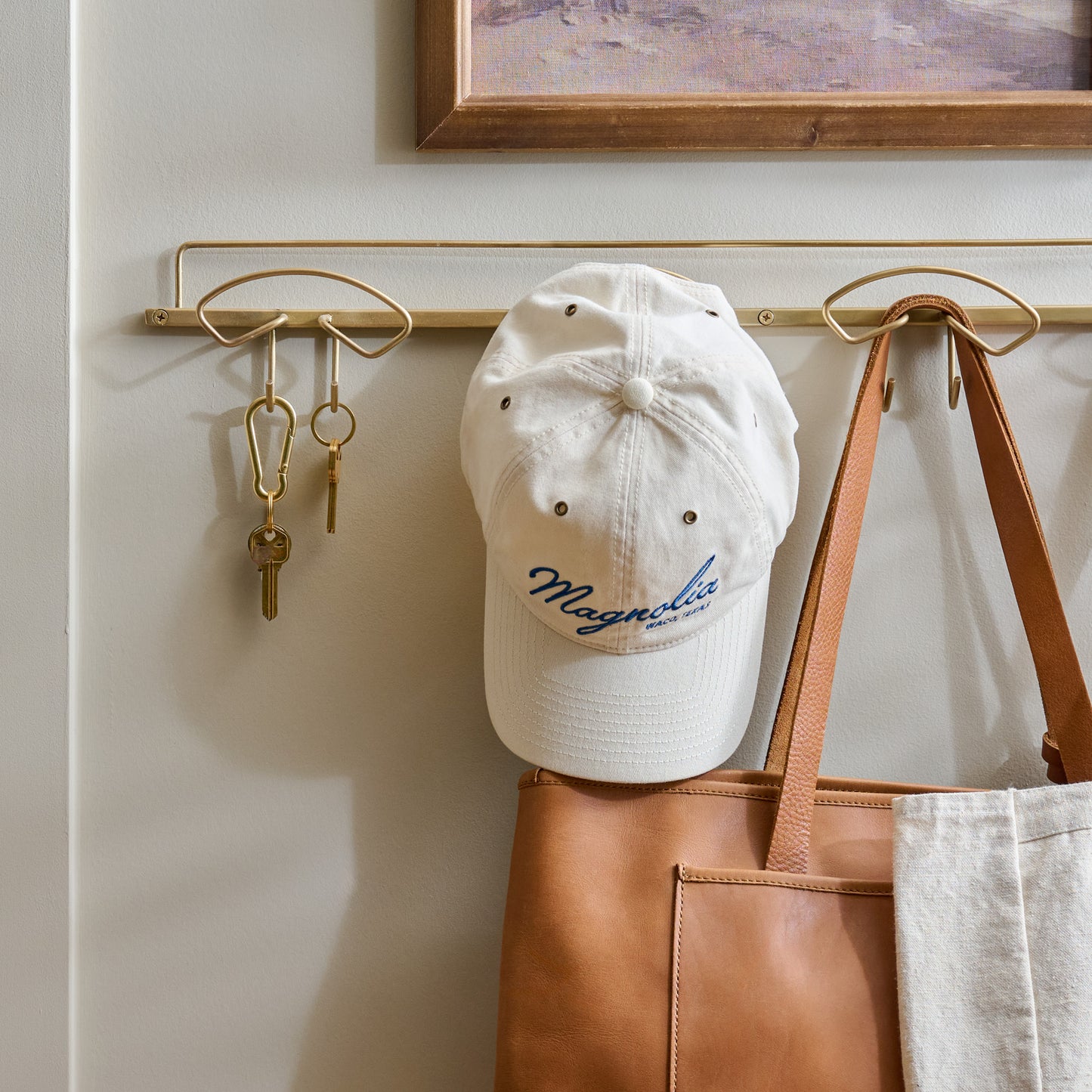 Antique Brass Wyatt Hooks on a wall with keys and accessories hanging
