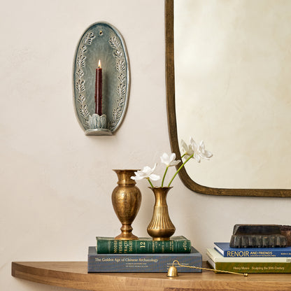 Annie Floral Ceramic Wall Sconce in a room next to mirror and above styled console table