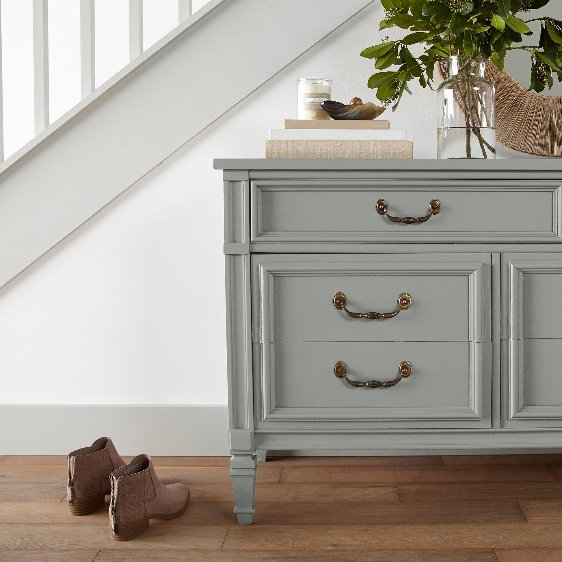 An overcast gray with hints of pale blue and green door and cabinet paint named weathered windmill shown painted on entryway cabinet