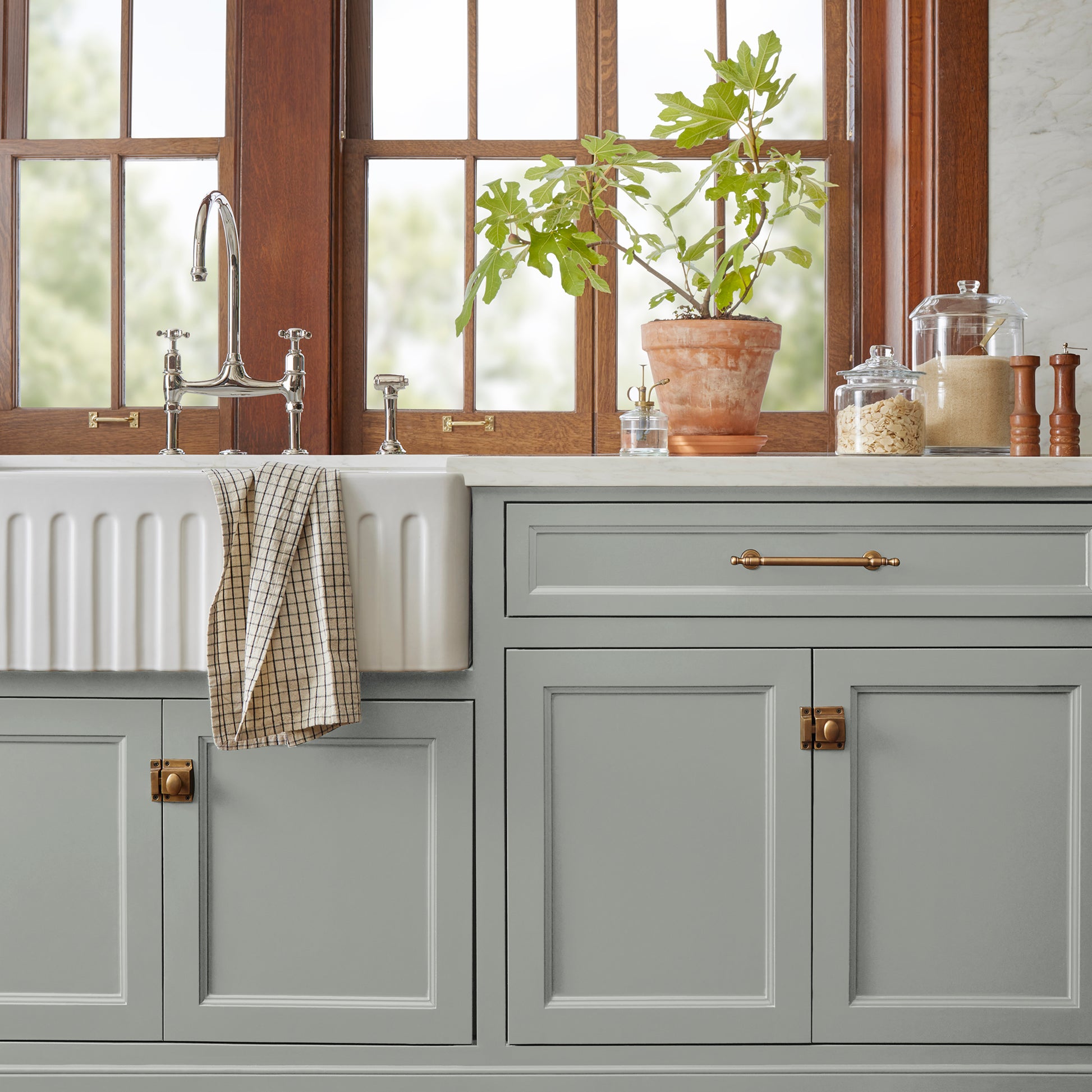 An overcast gray with hints of pale blue and green door and cabinet paint  named weathered windmill shown painted on kitchen cabinet