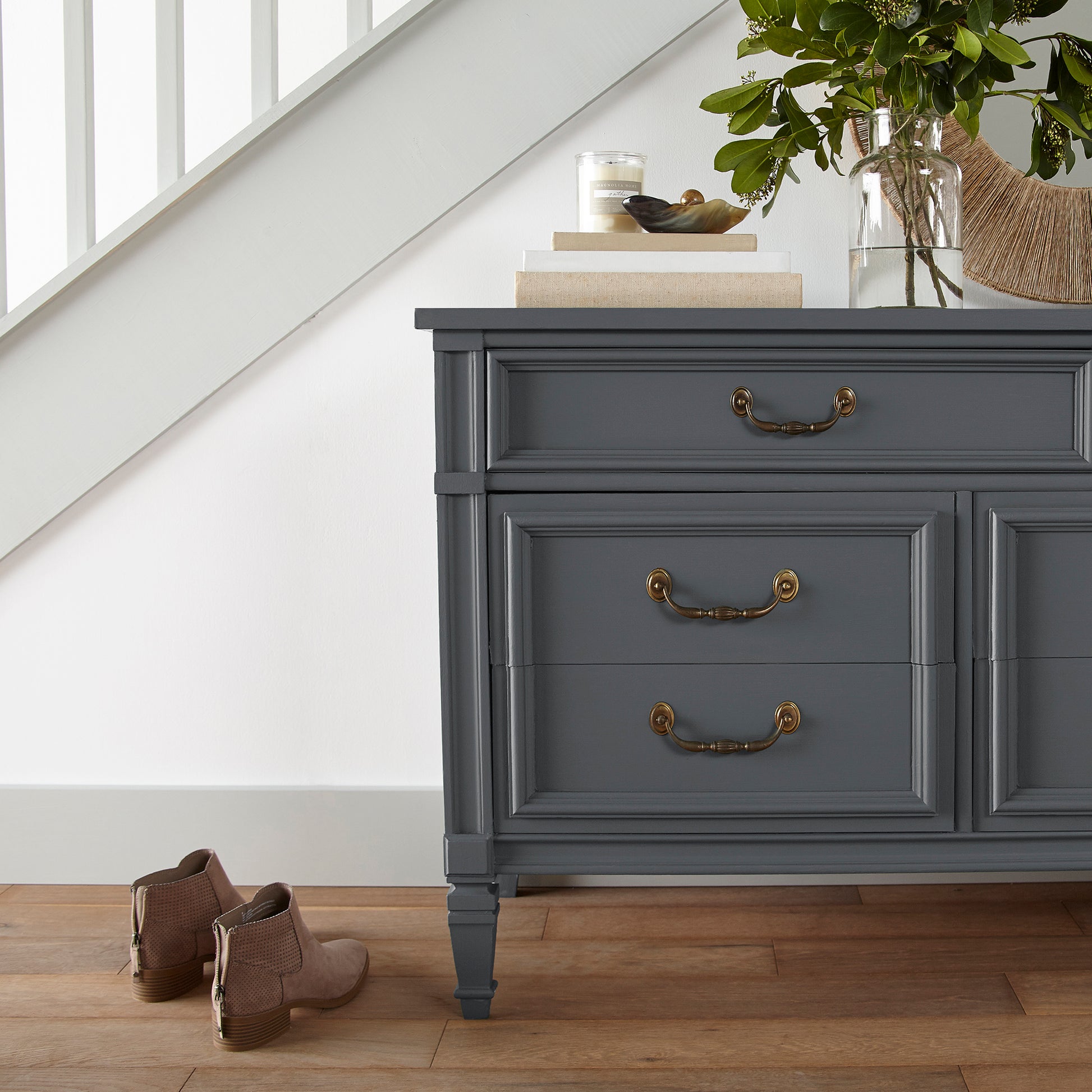 A dark chalkboard black with blue undertones paint named Blackboard shown painted on entryway cabinet.
