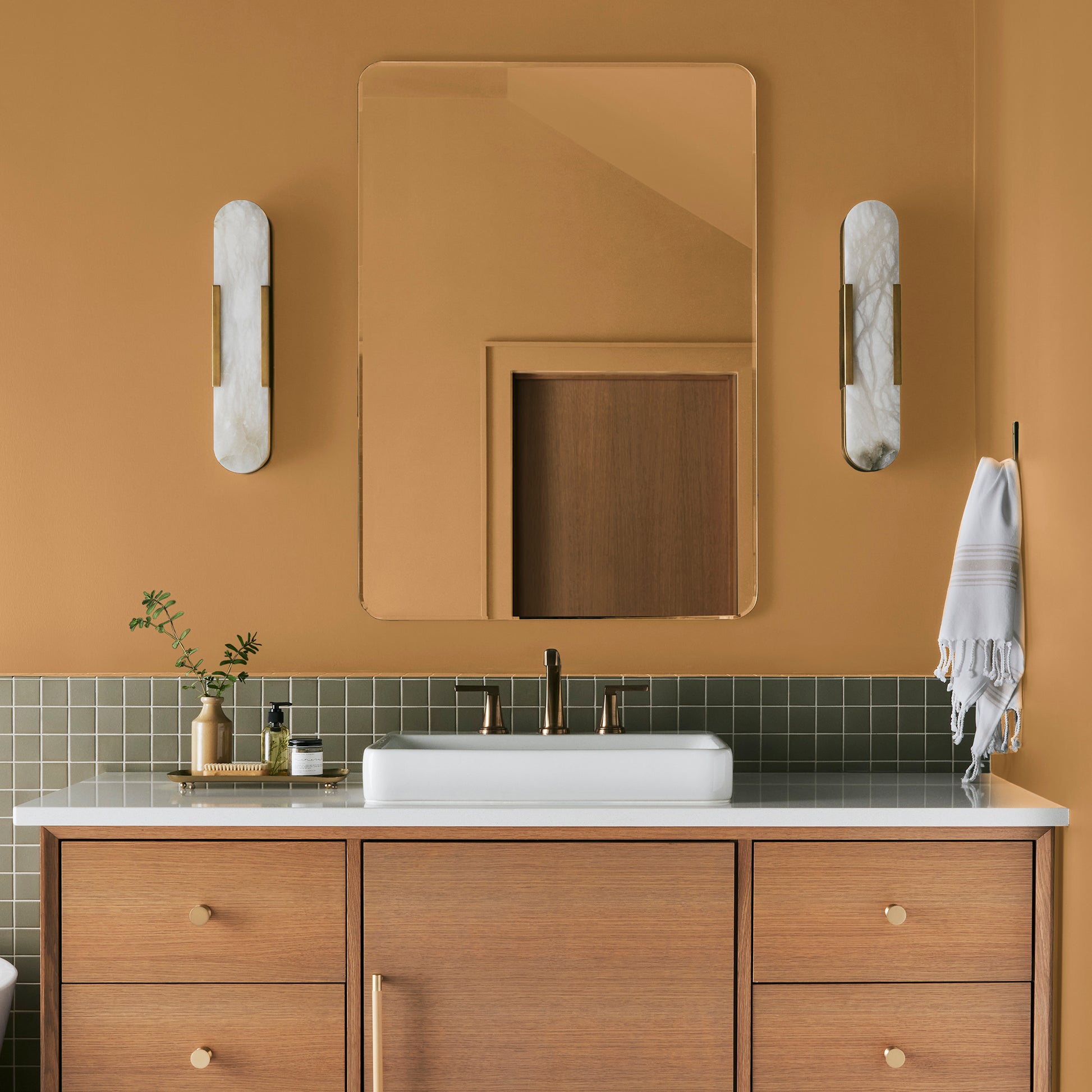 Rich ochre yellow interior paint named brushed clay shown painted on bathroom wall