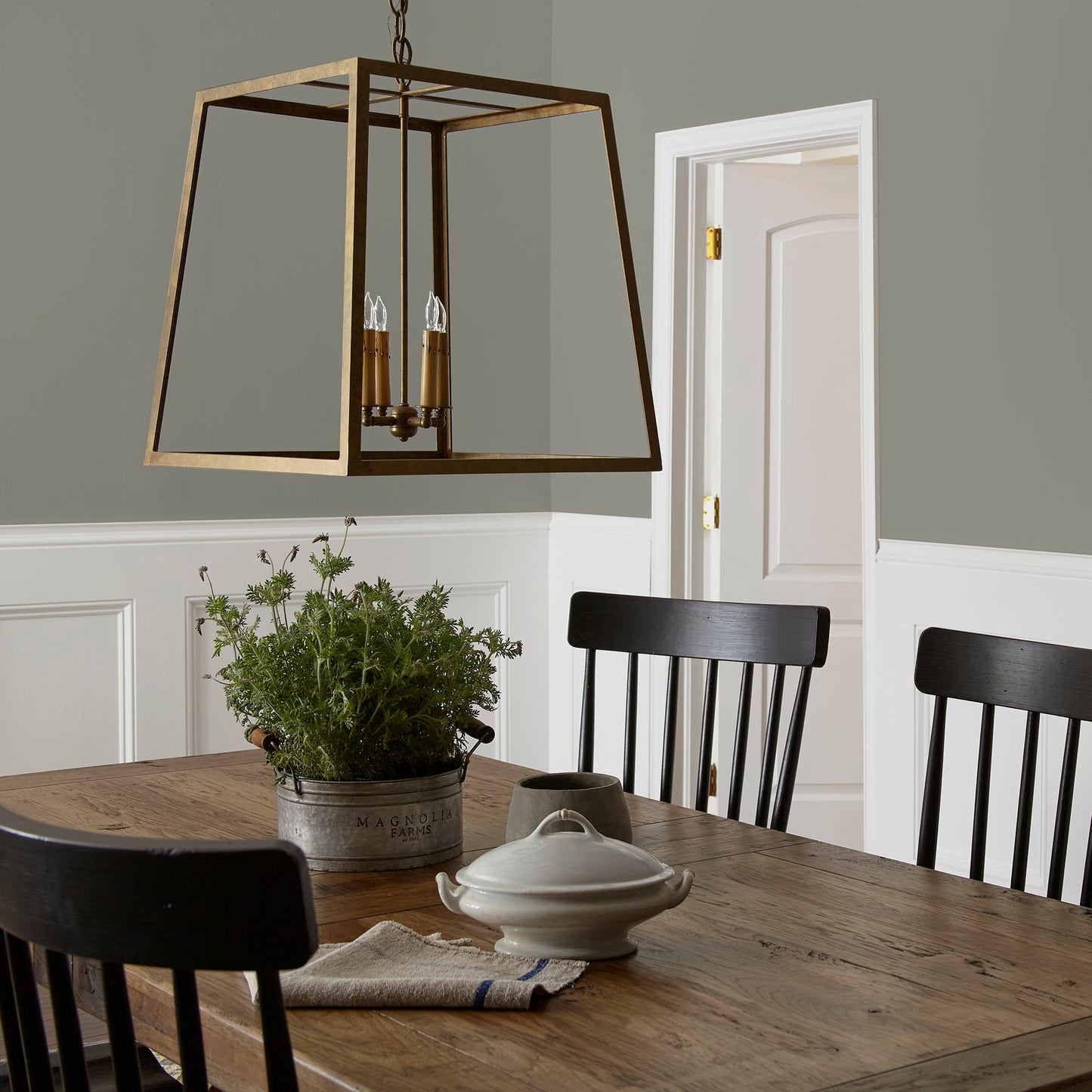 dark gray with olive green undertone paint named boutique gray shown painted on dining room wall
