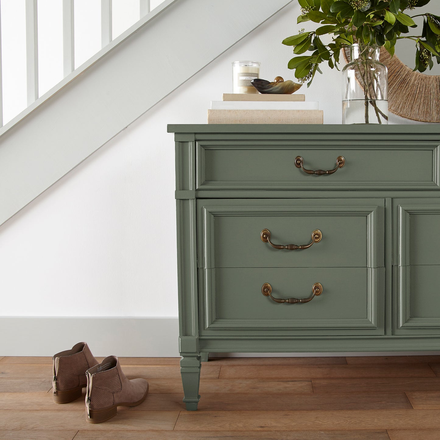 Dark and rich sage green door and cabinet paint named lemon leaves shown painted on entryway cabinet
