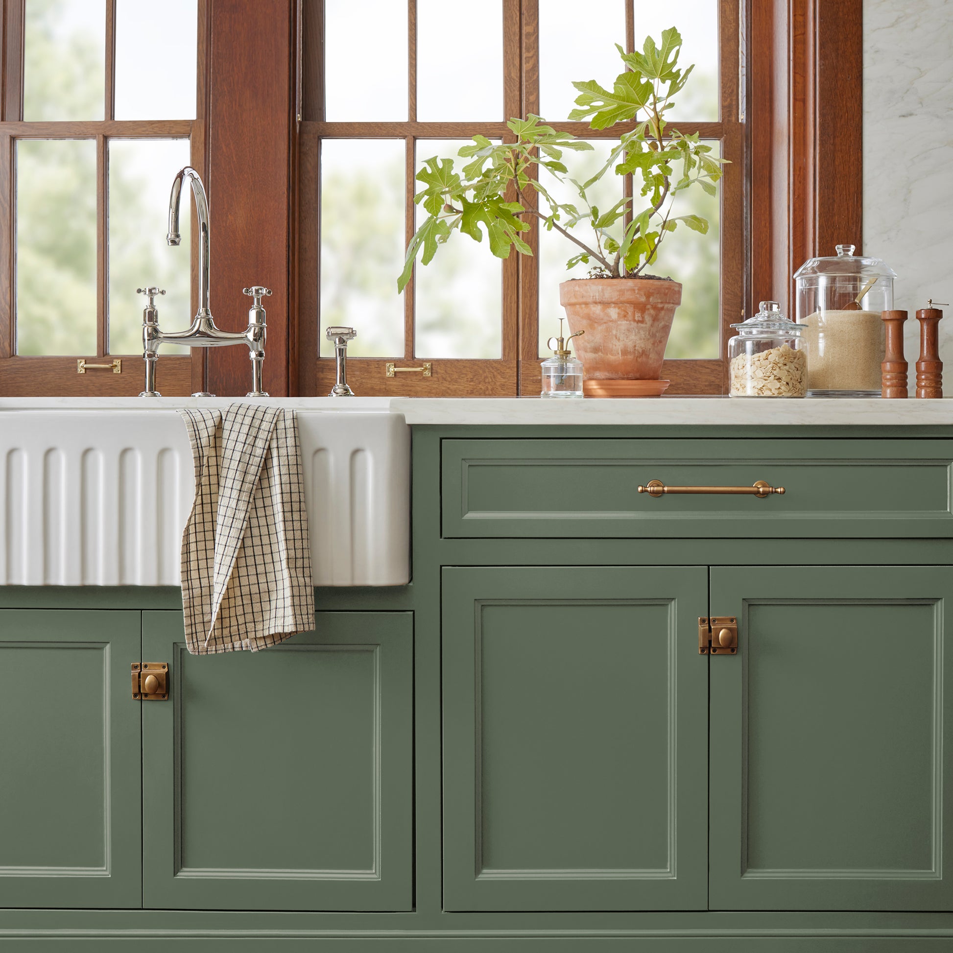 Dark and rich sage green door and cabinet paint named lemon leaves shown painted on kitchen cabinet  